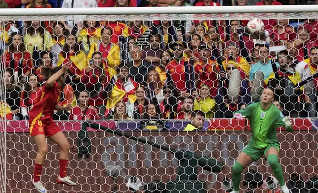 Spain's Mariona Caldentey, left, scores her sides first goal past England goalkeeper Hannah Hampton during the Women's Euro 2025 final soccer match between England and Spain at St. Jakob-Park in Basel, Switzerland, Sunday, July 27, 2025. (AP Photo/Martin Meissner)