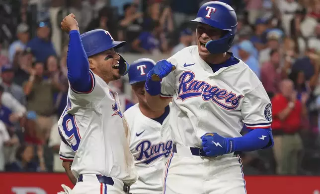 Texas Rangers' Michael Helman, right, celebrates after hitting a home run that also scored teammates Cody Freeman, left, and Josh Jung, center, during the fifth inning of a baseball game against the Athletics, Monday, July 21, 2025, in Arlington, Texas. (AP Photo/LM Otero)