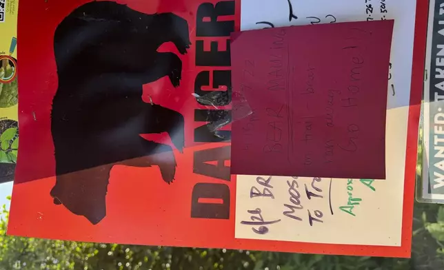 A bear warning sign is posted at the Basher trailhead in Anchorage, Alaska, on Wednesday, July 23, 2025, a day after a hiker was injured by a brown bear about two miles into the trail. (AP Photo/Mark Thiessen)