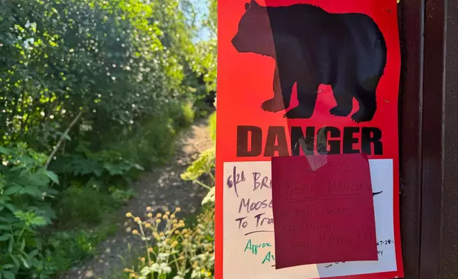 A bear warning sign is posted at the Basher trailhead in Anchorage, Alaska, on Wednesday, July 23, 2025, a day after a hiker was injured by a brown bear about two miles into the trail. (AP Photo/Mark Thiessen)