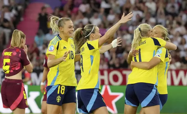 Sweden's Smilla Holmberg, right, celebrates with Stina Blackstenius, Kosovare Asllani and Fridolina Rolfo, after scoring her side's second goal during the Women's Euro 2025, group C, soccer match between Sweden and Germany at Stadion Letzigrund in Zurich, Switzerland, Saturday, July 12, 2025. (AP Photo/Martin Meissner)