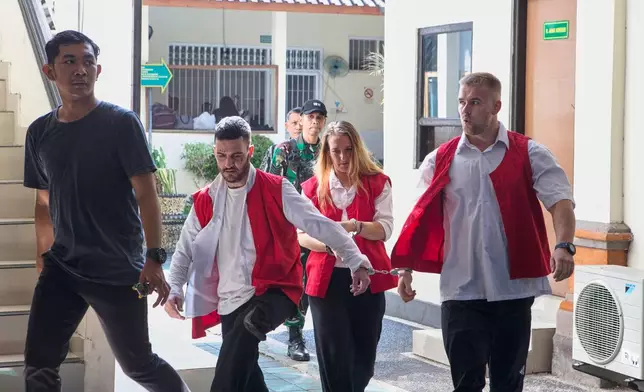 British nationals, from right, Phineas Float, Lisa Stocker and Jonathan Collyer, who are accused of smuggling nearly a kilogram (over two pounds) of cocaine into Indonesia are escorted by a security officer before their verdict at the district court in Denpasar, Bali, Indonesia on Thursday, July 24, 2025. (AP Photo/Firdia Lisnawati)