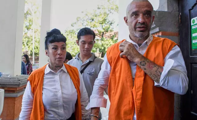 British national, Elliot James Shaw, right, and Argentine national Eleonora Gracia, who are accused of smuggling cocaine into Indonesia, walk to a holding cell after they are sentenced for drug offenses at the district court in Denpasar, Bali, Indonesia on Thursday, July 24, 2025. (AP Photo/Firdia Lisnawati)
