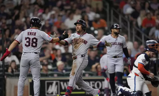 Cleveland Guardians' José Ramírez, center, celebrates with Steven Kwan (38) after both scored on Ramírez's three-run home run against the Houston Astros during the fifth inning of a baseball game Monday, July 7, 2025, in Houston. (AP Photo/David J. Phillip)