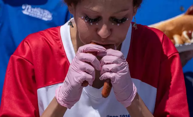 Competitive eater Dominica Dee eats hot dog during the 2025 Nathan's Famous Fourth of July hot dog eating contest in the Coney Island section of the Brooklyn borough of New York, Thursday, July 4, 2025. (AP Photo/Yuki Iwamura)