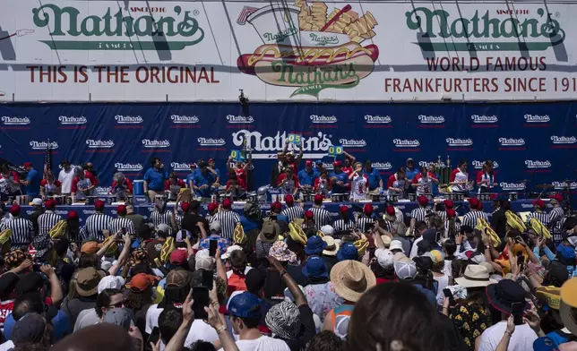 Competitive eaters eat hot dogs during the 2025 Nathan's Famous Fourth of July hot dog eating contest in the Coney Island section of the Brooklyn borough of New York, Thursday, July 4, 2025. (AP Photo/Yuki Iwamura)