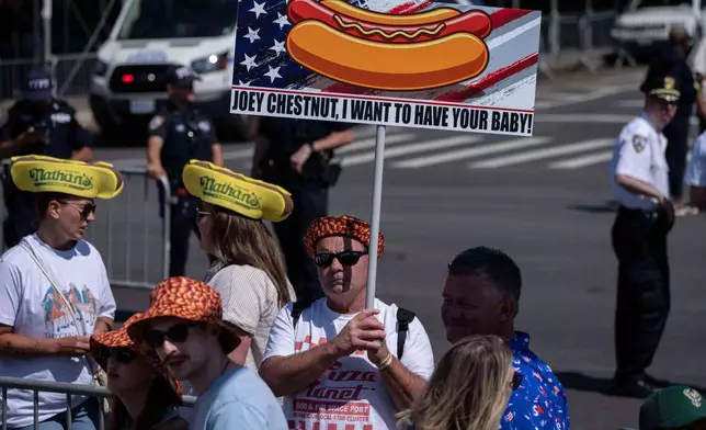 A person raises a sign in support of a competitive eater Joey Chestnut ahead of the 2025 Nathan's Famous Fourth of July hot dog eating contest in the Coney Island section of the Brooklyn borough of New York, Thursday, July 4, 2025. (AP Photo/Yuki Iwamura)