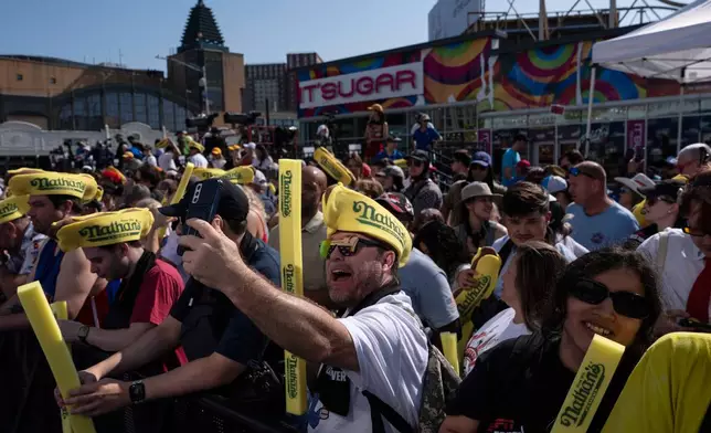 People wait for the 2025 Nathan's Famous Fourth of July hot dog eating contest in the Coney Island section of the Brooklyn borough of New York, Thursday, July 4, 2025. (AP Photo/Yuki Iwamura)