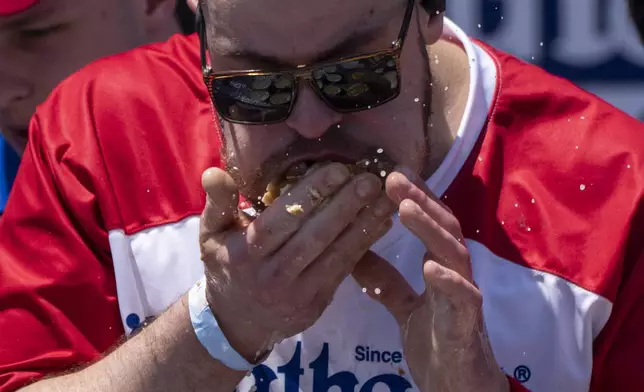 Competitive eater Patrick Bertoletti eats hot dogs during the 2025 Nathan's Famous Fourth of July hot dog eating contest in the Coney Island section of the Brooklyn borough of New York, Thursday, July 4, 2025. (AP Photo/Yuki Iwamura)