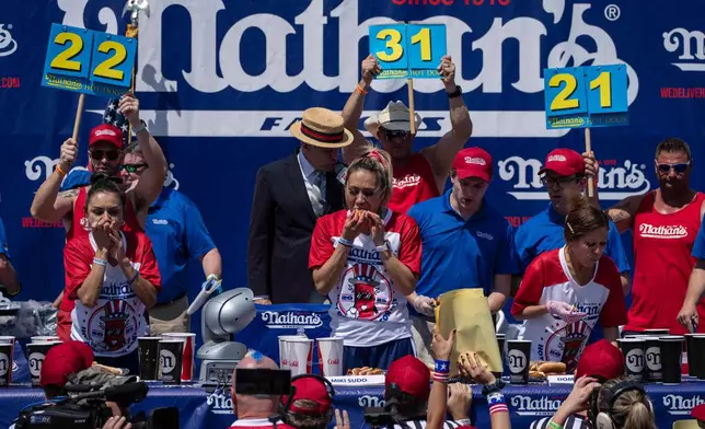 Competitive eaters eat hot dogs during the 2025 Nathan's Famous Fourth of July hot dog eating contest in the Coney Island section of the Brooklyn borough of New York, Thursday, July 4, 2025. (AP Photo/Yuki Iwamura)