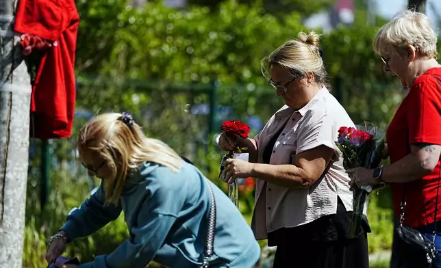 People lay flowers as tributes in memory of Liverpool player Diogo Jota, at Anfield Stadium, home of Liverpool, Thursday July 3, 2025. (Peter Byrne/PA via AP)