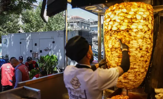 A privately-owned electricity generator, left, stationed outside a restaurant in Damascus, Syria, Monday, July 3, 2025. (AP Photo/Ghaith Alsayed)