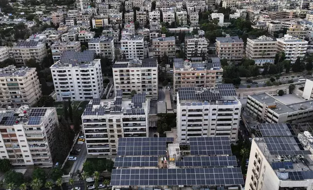 An aerial view shows solar panels installed on building rooftops in Damascus, Syria, Monday, June 30, 2025. (AP Photo/Ghaith Alsayed)