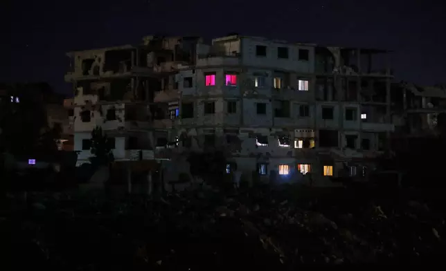 FILE - Lights illuminate a few windows of a damaged building in Damascus, Syria, early Thursday, March 27, 2025. (AP Photo/Omar Sanadiki, File)