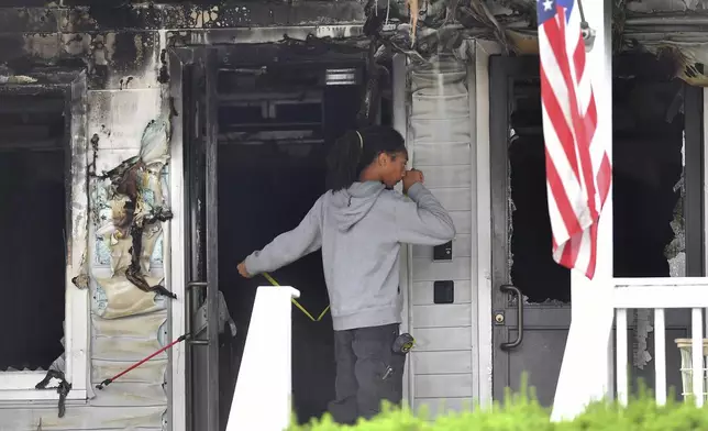 An investigator takes measurements Monday, July 14, 2025, near an entrance to the Gabriel House assisted living facility following a fire that started late Sunday, in Fall River, Mass. (AP Photo/Steven Senne)
