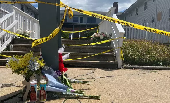 Flowers and candles sit in front of the Gabriel House assisted living home, where a fire on Sunday killed several people, Tuesday, July 15, 2025 in Fall River, Mass. (AP Photo/Kimberlee Kruesi)