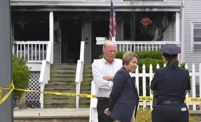 Massachusetts Gov. Maura Healey, center, and Fall River Mayor Paul Coogan, left, speak with a member of law enforcement, right, near the Gabriel House assisted living facility, Monday, July 14, 2025, following a fire that started late Sunday, in Fall River, Mass. (AP Photo/Steven Senne)