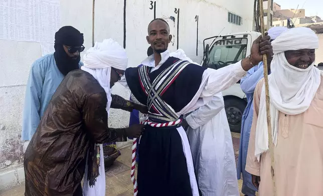 A dancer from El Mihan, Algeria prepares for the Sebeiba festival dance competition in Djanet, a southeastern Algerian oasis town in the Sahara desert, on July 6, 2025. (AP Photo/Audrey Thibert)