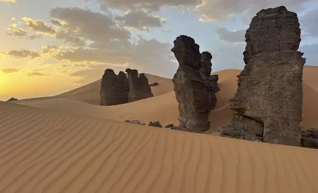 Rock formations stand in the Sahara desert outside the city center of Djanet, a southeastern Algerian oasis town in the Sahara desert, on July 5, 2025. (AP Photo/Audrey Thibert)