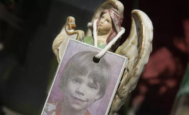 FILE - A photograph of Etan Patz hangs on an angel figurine, as part of a makeshift memorial in the SoHo neighborhood of New York, May 28, 2012. (AP Photo/Mark Lennihan, File)