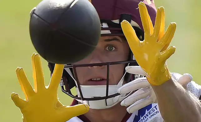 Washington Commanders wide receiver Luke McCaffrey (11) catches a ball during practice at the team's NFL football training camp, Thursday, July 24, 2025, in Ashburn, Va. (AP Photo/Mark Schiefelbein)