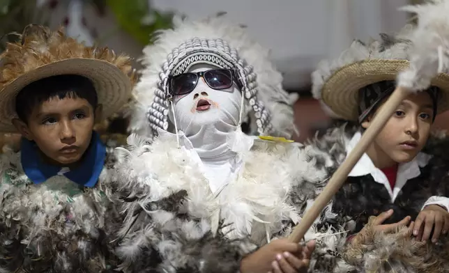 Children dressed in feather costumes attend a Mass celebrating Saint Francisco Solano, in Emboscada, Paraguay, Thursday, July 24, 2025. Hundreds of Catholic parishioners in Paraguay don bird-like costumes and parade down the streets to honor the 16th century saint said to possess miraculous powers. (AP Photo/Jorge Saenz)
