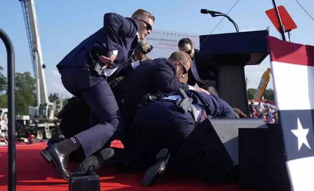 FILE - Republican presidential candidate former President Donald Trump is covered by U.S. Secret Service agents at a campaign rally, July 13, 2024, in Butler, Pa. (AP Photo/Evan Vucci, File)