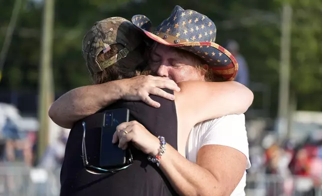 FILE - People hug after Republican presidential candidate former President Donald Trump was helped off the stage at a campaign event in Butler, Pa., July 13, 2024. (AP Photo/Gene J. Puskar, File)