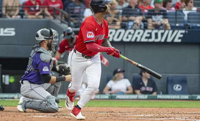 Cleveland Guardians' Brayan Rocchio, right, watches his sacrifice fly with Colorado Rockies' Austin Nola, left, during the fourth inning of a baseball game, Wednesday, July 30, 2025, in Cleveland. (AP Photo/Phil Long)