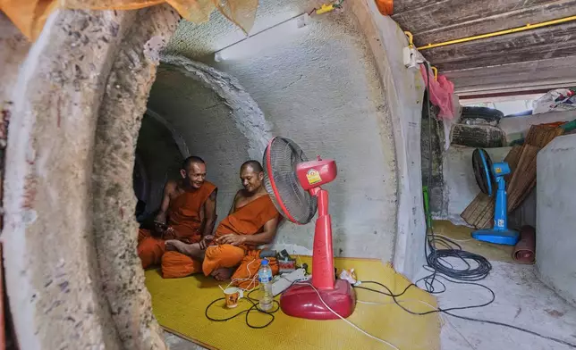 Thai Buddhist monks who fled clashes between Thai and Cambodian soldiers take shelter in Surin province, Thailand, Saturday, July 26, 2025. (AP Photo/Sakchai Lalit)