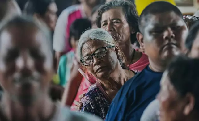 Thai residents who fled homes following clashes between Thai and Cambodian soldiers line up to receive toiletry distributed by a group of elderly in Surin who learn ballroom dance together, at an evacuation center in Surin province, Thailand, Saturday, July 26, 2025. (AP Photo/Sakchai Lalit)