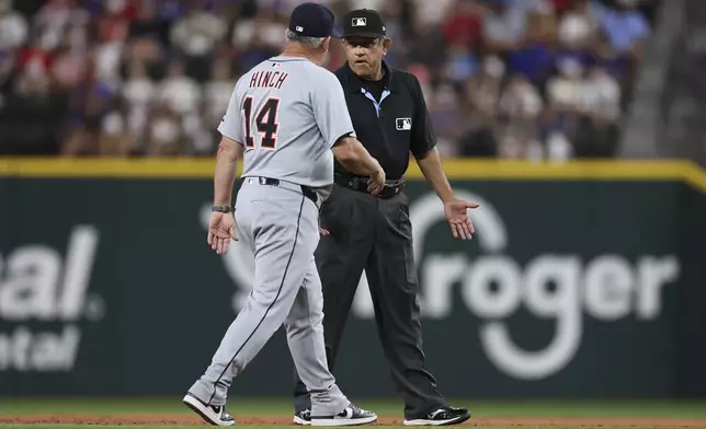 Detroit Tigers manager A.J. Hinch (14) and second base umpire Alfonso Márquez exchange words during the third inning of a baseball game against the Texas Rangers Friday, July 18, 2025, in Arlington, Texas. (AP Photo/Sam Hodde)
