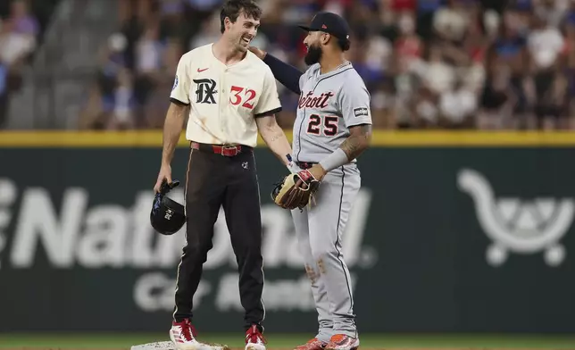 Texas Rangers' Evan Carter and Detroit Tigers second baseman Gleyber Torres exchange words after colliding on a play at second base during the second inning of a baseball game on Friday, July 18, 2025, in Arlington, Texas. (AP Photo/Sam Hodde)