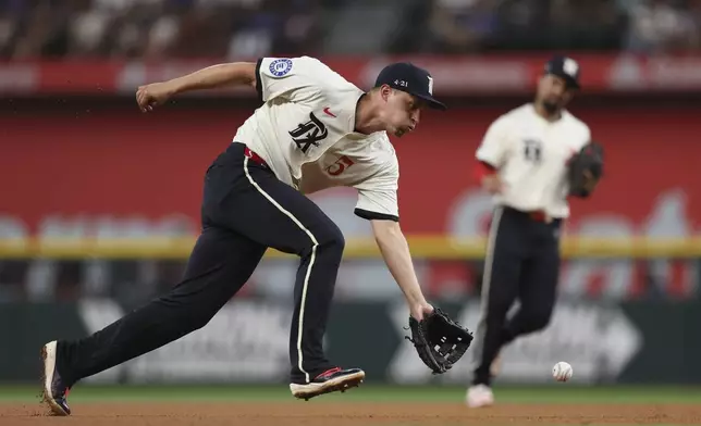 Texas Rangers shortstop Corey Seager (5) fields a ground ball hit by Detroit Tigers' Spencer Torkelson during the fourth inning of a baseball game on Friday, July 18, 2025, in Arlington, Texas. (AP Photo/Sam Hodde)