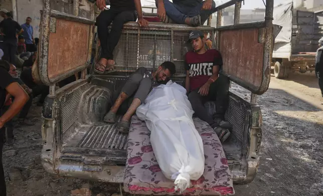 Palestinians mourn around the body of a man killed while trying to reach aid trucks entering northern Gaza through the Zikim crossing with Israel, at Shifa Hospital in Gaza City, Thursday, July 31, 2025. (AP Photo/Jehad Alshrafi)