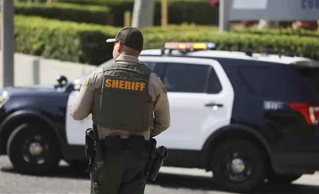 A sheriffs deputy monitors a street closure near the site of an explosion at the LA County Sheriff's Special Operations Bureau on Friday, July 18, 2025, in Los Angeles. (AP Photo/Etienne Laurent)