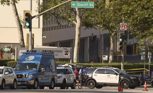 Media and law enforcement stage near the site of an explosion at the LA County Sheriff's Special Operations Bureau on Friday, July 18, 2025, in Los Angeles. (AP Photo/Etienne Laurent)