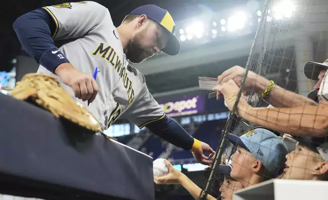 Milwaukee Brewers' Rhys Hoskins signs autographs before a baseball game against the Miami Marlins, Saturday, July 5, 2025, in Miami. (AP Photo/Lynne Sladky)