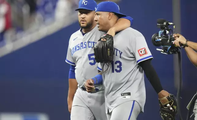 Kansas City Royals relief pitcher Carlos Estevez, left, and first baseman Salvador Perez (13) walk from the field after defeating the Miami Marlins in a baseball game, Sunday, July 20, 2025, in Miami. (AP Photo/Lynne Sladky)