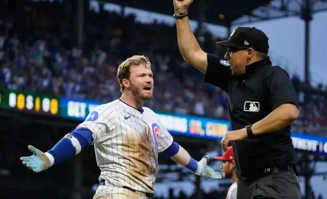 Chicago Cubs' Ian Happ, left, is called out at first base by umpire Adam Hamari, right, during the third inning of a baseball game against the St. Louis Cardianls, Sunday, July 6, 2025, in Chicago. (AP Photo/David Banks)