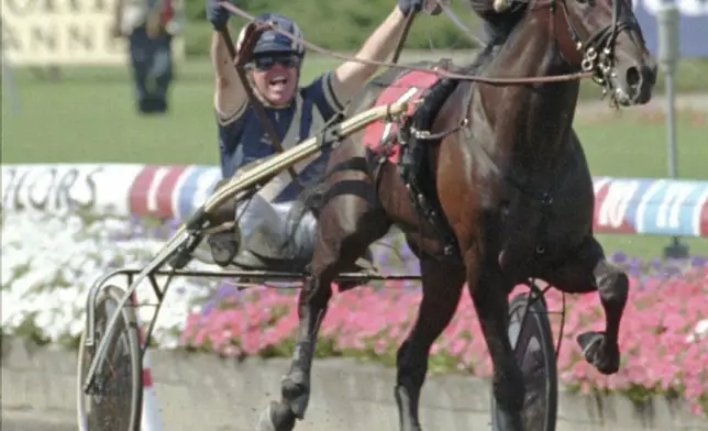 FILE - Malvern Burroughs celebrates after crossing the finish line with Malabar Man to win the $1 million Hambletonian at Meadowlands Racetrack in East Rutherford, N.J., Saturday, Aug. 9, 1997. (AP Photo/Daniel Hulshizer, File)