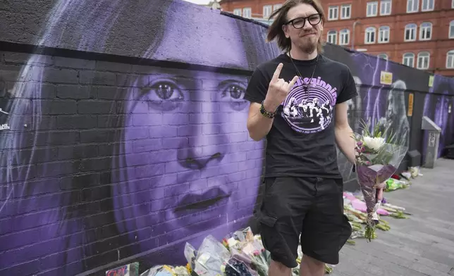 Music fan Matthew Caldwell holds flowers to commemorate the death of Ozzy Osbourne in Birmingham, Wednesday, July 23, 2025. (AP Photo/Kin Cheung)