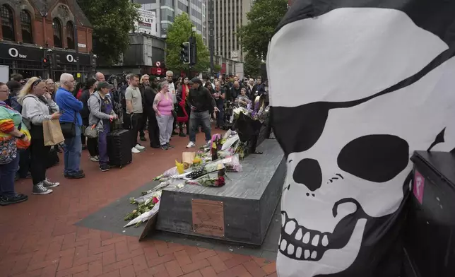 Flowers are left by fans to commemorate the death of Ozzy Osbourne at the Black Sabbath Bridge in Birmingham, Wednesday, July 23, 2025. (AP Photo/Kin Cheung)