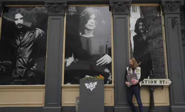Stephen Veland poses for a photograph outside The Crown Pub to commemorate the death of Ozzy Osbourne, in Birmingham, Wednesday, July 23, 2025. (AP Photo/Kin Cheung)