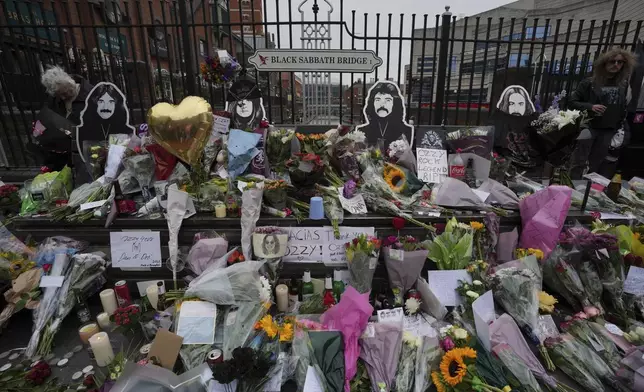 Flowers are left by fans to commemorate the death of Ozzy Osbourne at the Black Sabbath Bridge in Birmingham, Wednesday, July 23, 2025. (AP Photo/Kin Cheung)