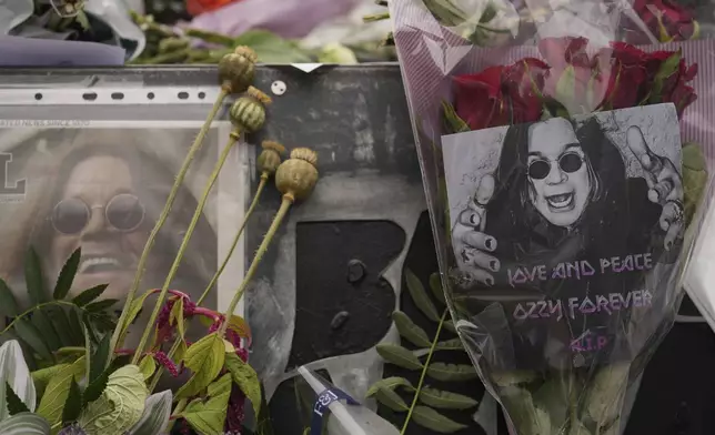 Flowers and messages are left by fans to commemorate the death of Ozzy Osbourne at the Black Sabbath Bridge in Birmingham, Wednesday, July 23, 2025. (AP Photo/Kin Cheung)