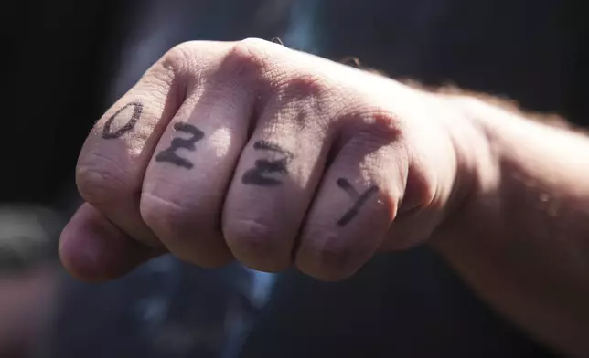 A person displays Ozzy Osbourne's name marked on their knuckles at the Hollywood Walk of Fame on Tuesday, July 22, 2025, in Los Angeles. (AP Photo/Damian Dovarganes)