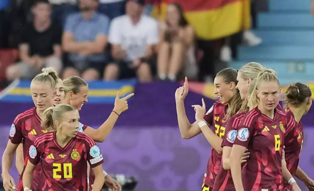 Germany's Jule Brand, center right, celebrates with Klara Buehl, center left, after scoring the opening goal during the Women's Euro 2025, group C, soccer match between Sweden and Germany at Stadion Letzigrund in Zurich, Switzerland, Saturday, July 12, 2025. (AP Photo/Martin Meissner)