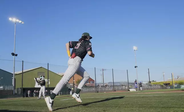 Oakland Ballers' Lou Helmig runs onto the field while being introduced before a Pioneer League baseball game against the Rocky Mountain Vibes in Oakland, Calif., Thursday, July 10, 2025. (AP Photo/Jeff Chiu)