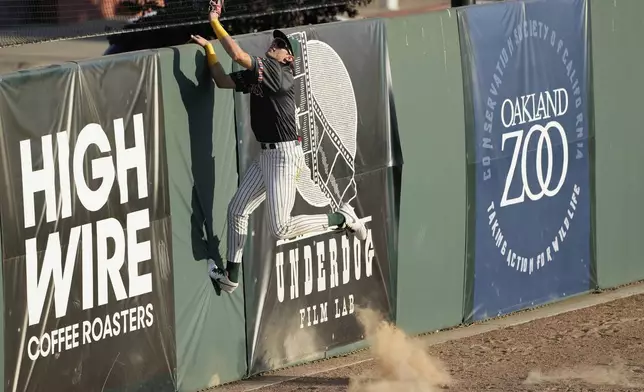 Oakland Ballers' Lou Helmig cannot catch a home run hit by Rocky Mountain Vibes' Gary Lora Gonzalez during the third inning of a Pioneer League baseball game in Oakland, Calif., Thursday, July 10, 2025. (AP Photo/Jeff Chiu)